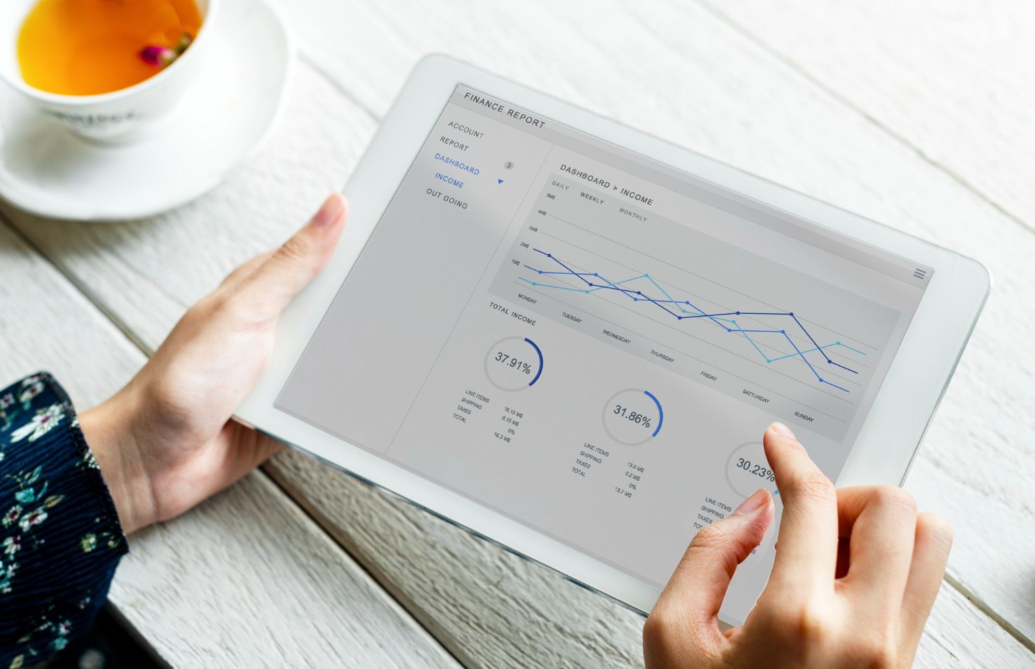 Persona sujetando una tablet que muestra gráficos de datos
